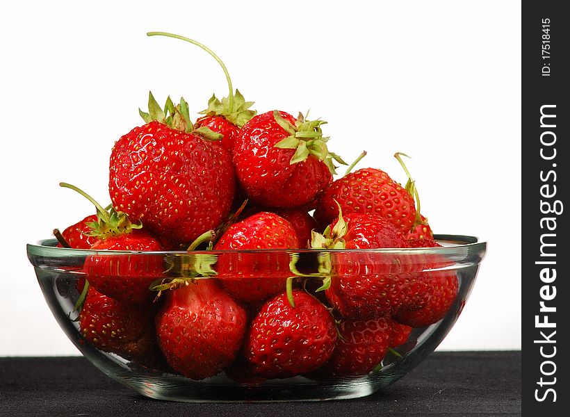 Glass bowl with strawberries on a white background