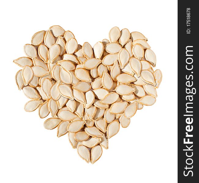 Heart from pumpkin seeds isolated on white background