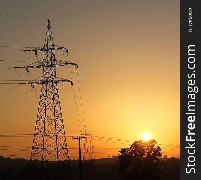 High voltage electricity pylon against sunset