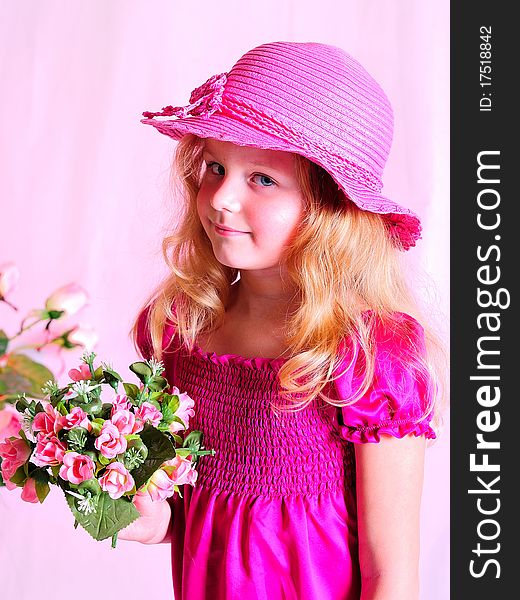 With a bouquet of flowers in a pink hat. With a bouquet of flowers in a pink hat