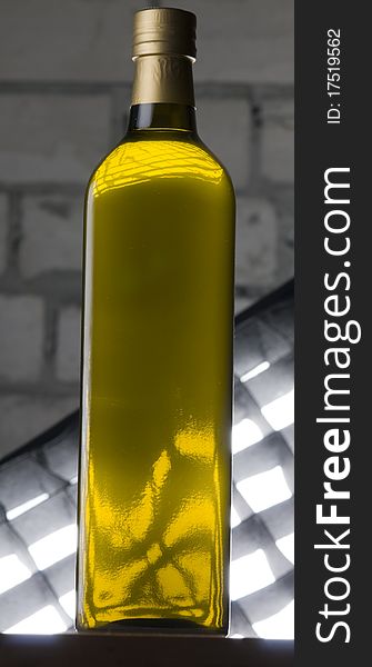 Olive oil bottle still-life over grey brick background