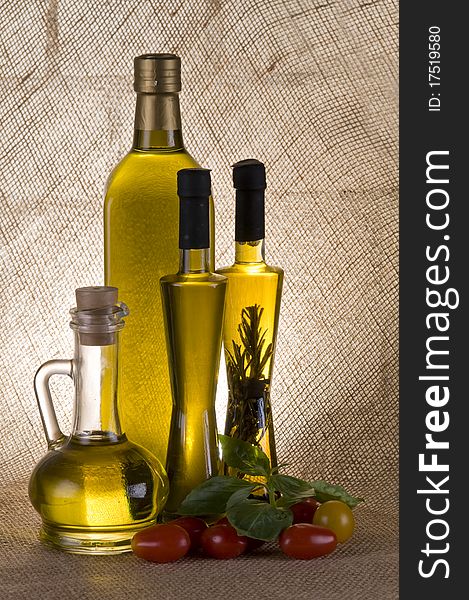 Olive oil bottle still-life over  textured background with back light. Olive oil bottle still-life over  textured background with back light