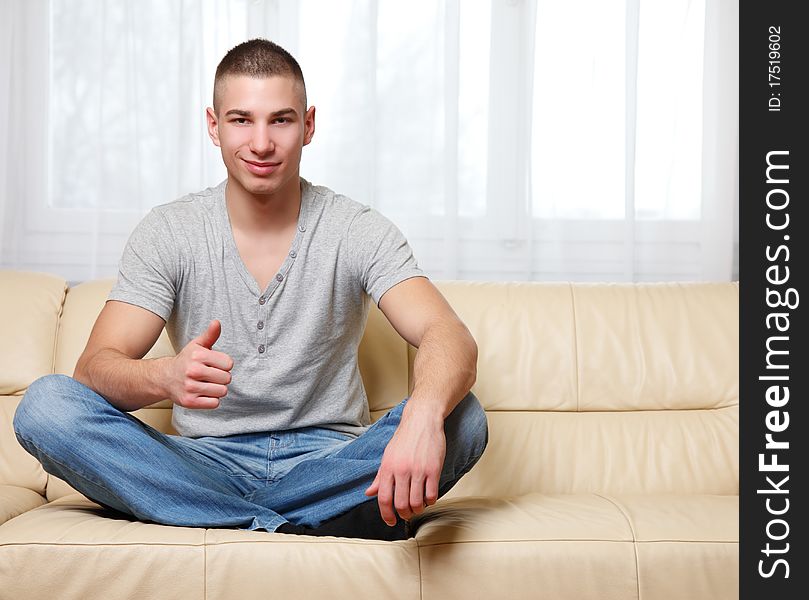 Young man sitting on the sofa. Young man sitting on the sofa