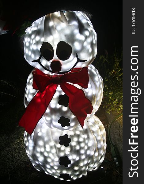 A lit snowman yard decoration celebrating Christmas and the winter holiday season.