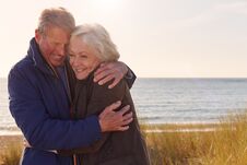 Loving Active Senior Couple Hugging As They Walk Through Sand Dunes Royalty Free Stock Photos