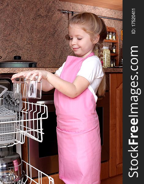 Little girl taken clear glass from dishwasher in the kitchen