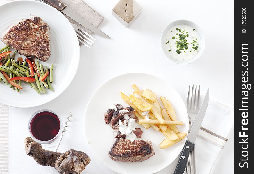 Steak with green vegetables and french fries, view directly from above. Steak with green vegetables and french fries, view directly from above.