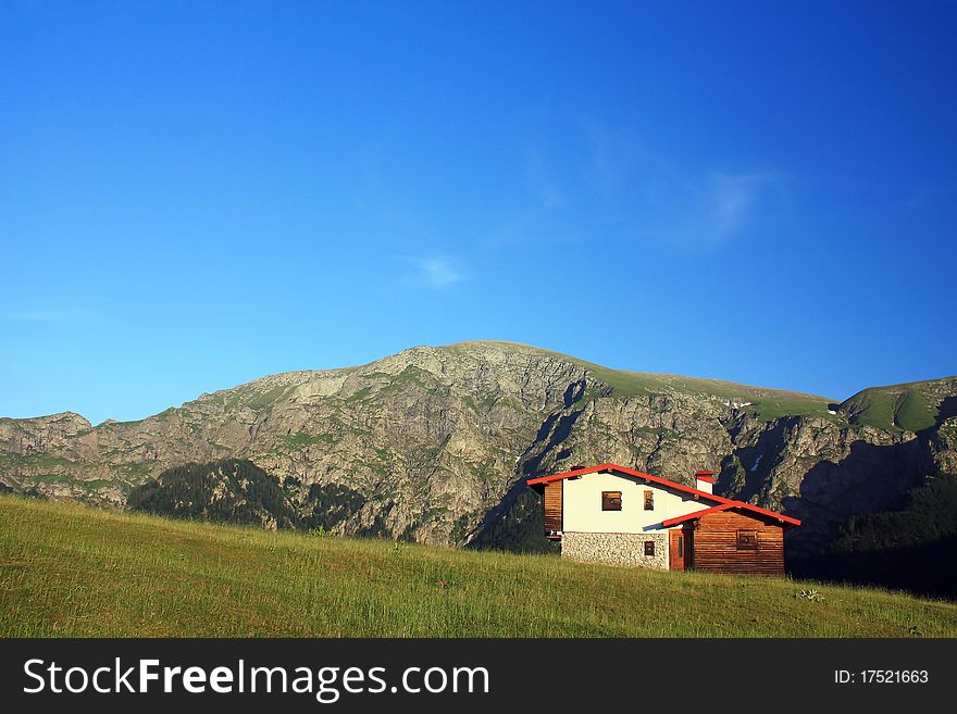 Hut in front of rocky mountain peak. Hut in front of rocky mountain peak