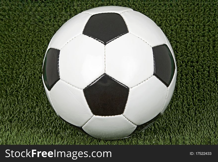 Soccer ball on green soccer meadow.