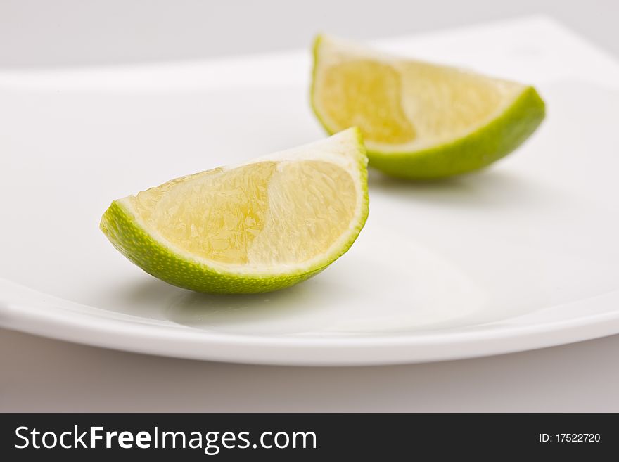 Food series: tasty green sliced lime on plate. Food series: tasty green sliced lime on plate