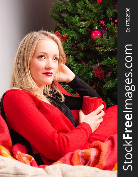 Young woman with the cup of tea near a new-year tree. Young woman with the cup of tea near a new-year tree