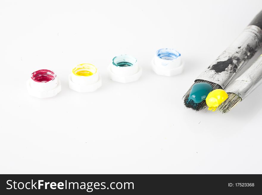 Close up shot on paint brushes isolated on white with paint tube caps