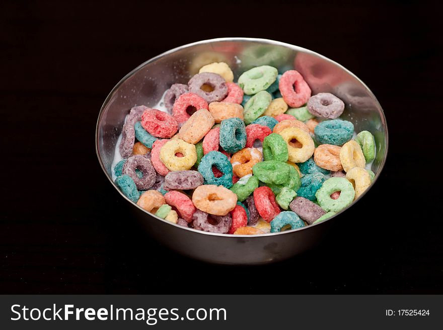 A bowl of looped cerals isolated on black background. A bowl of looped cerals isolated on black background