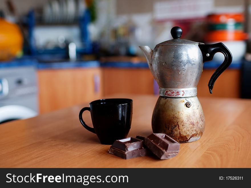 An image of coffee maker with cup and chokolate