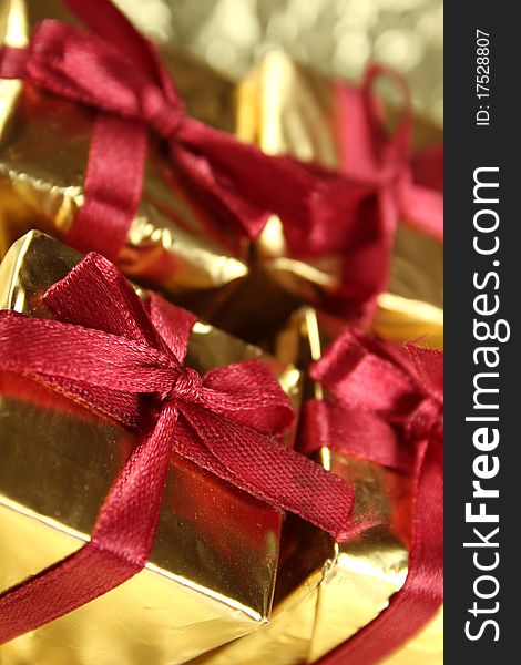 On a gold background four gold gift boxes with red ribbons. On a gold background four gold gift boxes with red ribbons