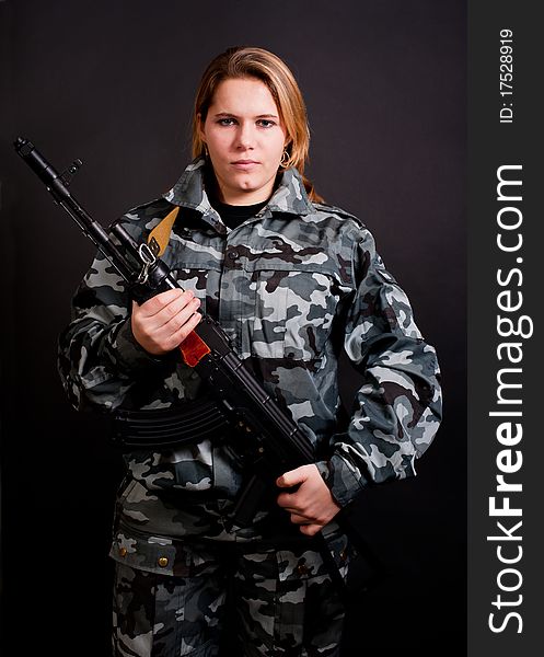 Girl in camouflage clothing holding gun. Girl in camouflage clothing holding gun