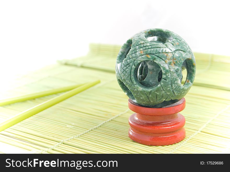 Jade sphere on a green bamboo rug. Jade sphere on a green bamboo rug