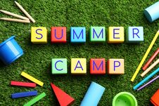 Flat Lay Composition With Phrase SUMMER CAMP Made Of Colorful Cubes On Green Grass Royalty Free Stock Photos