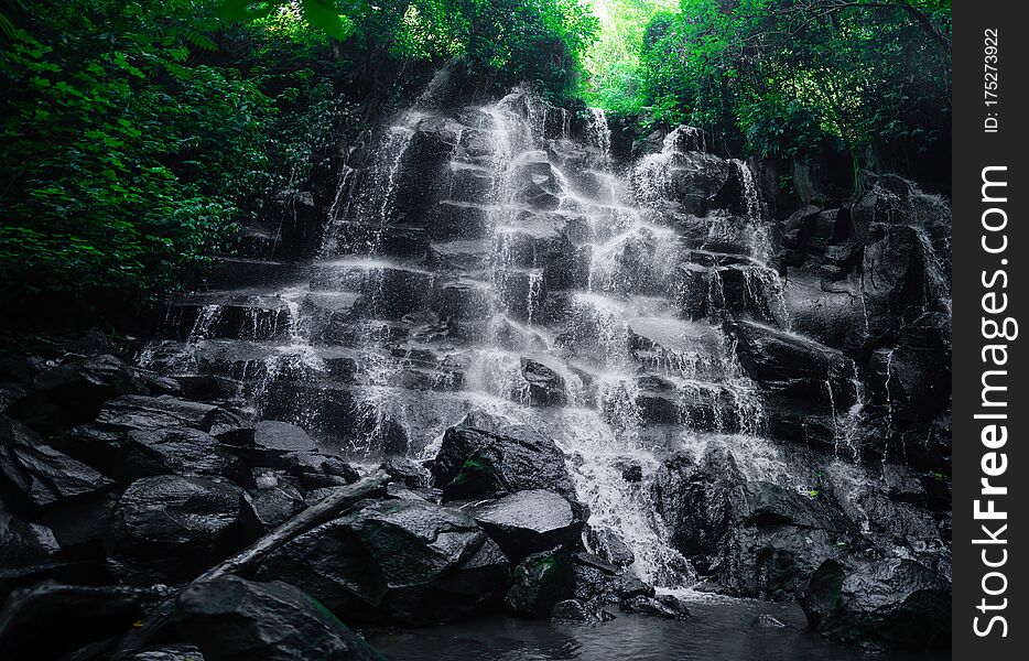Beautiful scenic view of beautiful Kanto Lampo waterfall flowing on rock in long exposure. Jungle river. Adventure in Asia, Bali Indonesia