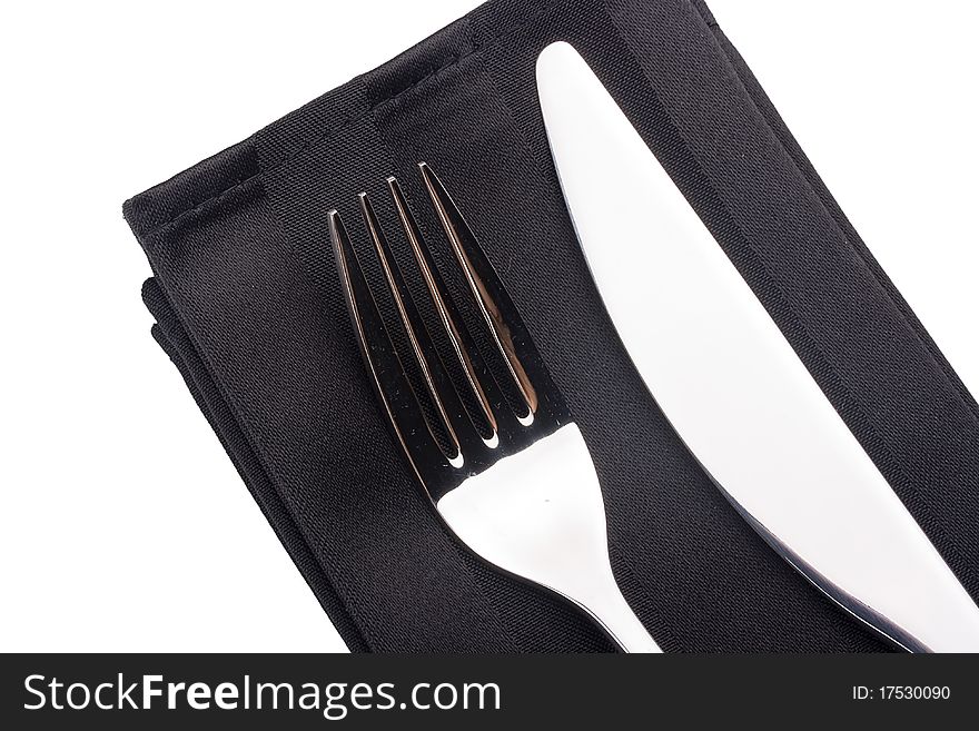 Knife and fork on a black napkin - tableware.