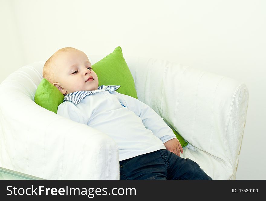 Young caucasian child resting in contemplation on an armchair. Young caucasian child resting in contemplation on an armchair