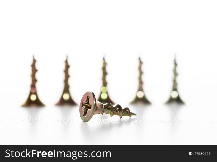 Abstract composition with few brass screws on white background