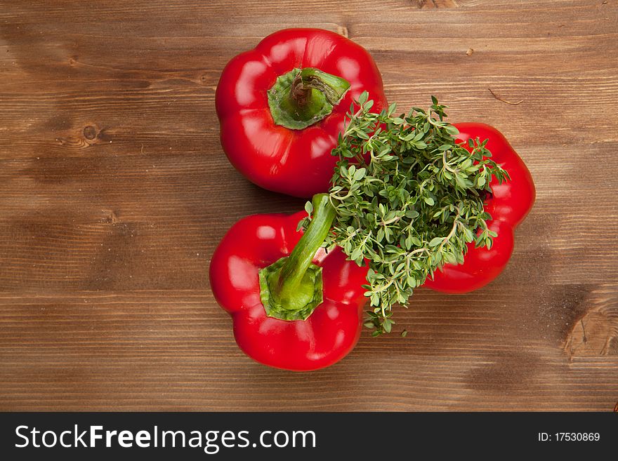 Red paprika withfresh herb on the wooden table. Red paprika withfresh herb on the wooden table