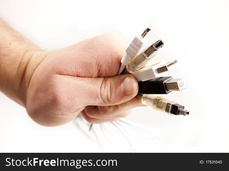 A hand with five different types of cords. USB and Firewire tips of the cables are shown on a white background. A hand with five different types of cords. USB and Firewire tips of the cables are shown on a white background.