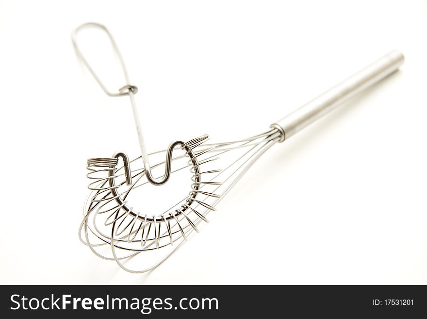 Whisk of metal onto white background