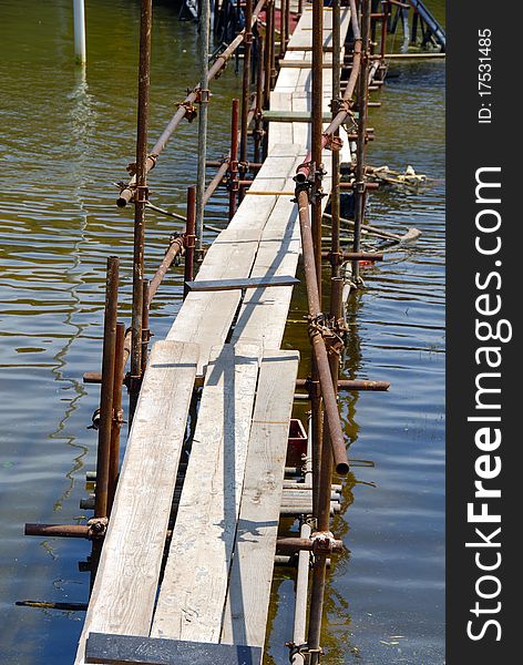 Bridge across water made from scaffolding and planks. Bridge across water made from scaffolding and planks