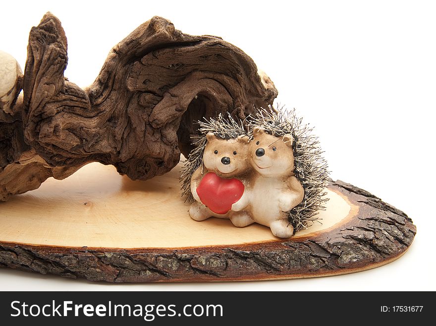 Old tree root with hedgehog pair and heart on wood board with bark