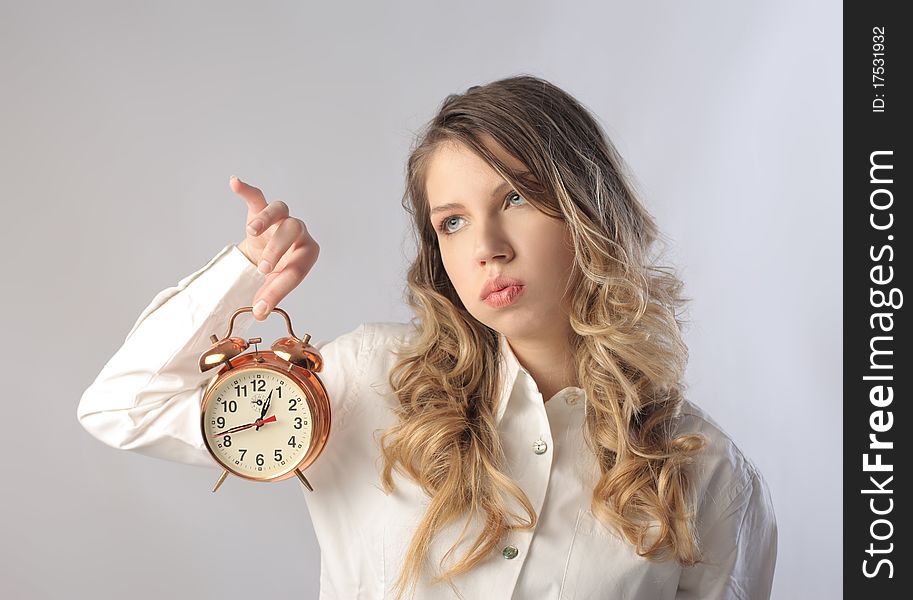 Bored woman holding an alarm clock. Bored woman holding an alarm clock