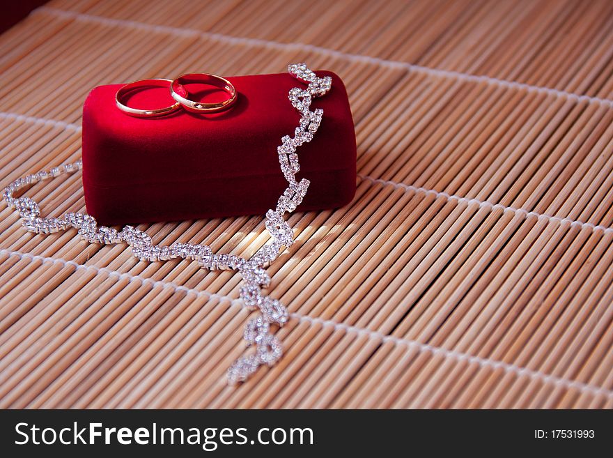 Two wedding rings of gold on the red box on the table. Two wedding rings of gold on the red box on the table