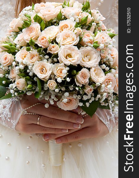 Bride holding wedding bouquet of roses in his hands