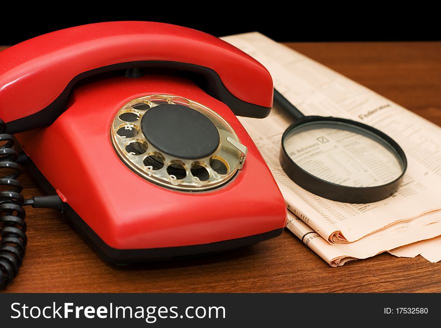 Red phone on a wooden table still life