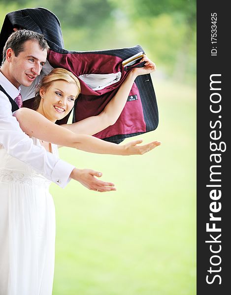 Cheerful young pair in  wedding day hides from  rain. Cheerful young pair in  wedding day hides from  rain