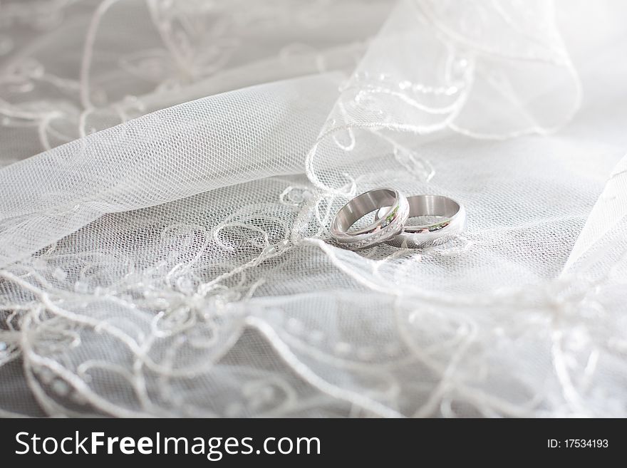 Ring of white gold are on the bride's white veil