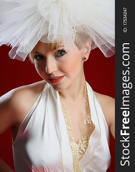 The charming bride in a wedding dress on a red background