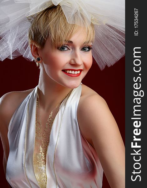 The charming bride in a wedding dress on a red background