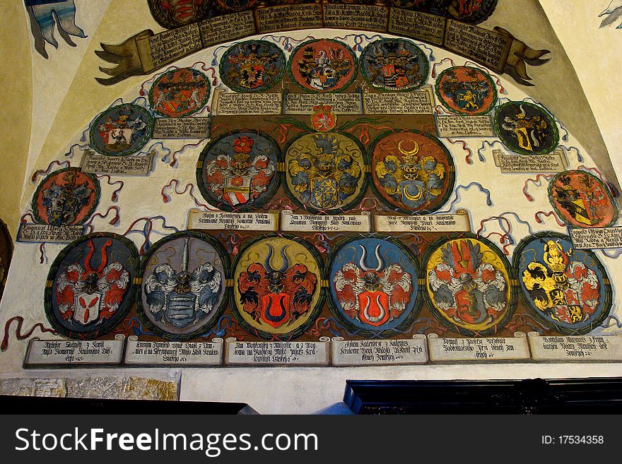 Detail of a room inside the Prague castle where there are some coats of arms pictured in the wall.