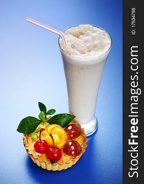 Milkshake and cake on a blue background. Milkshake and cake on a blue background