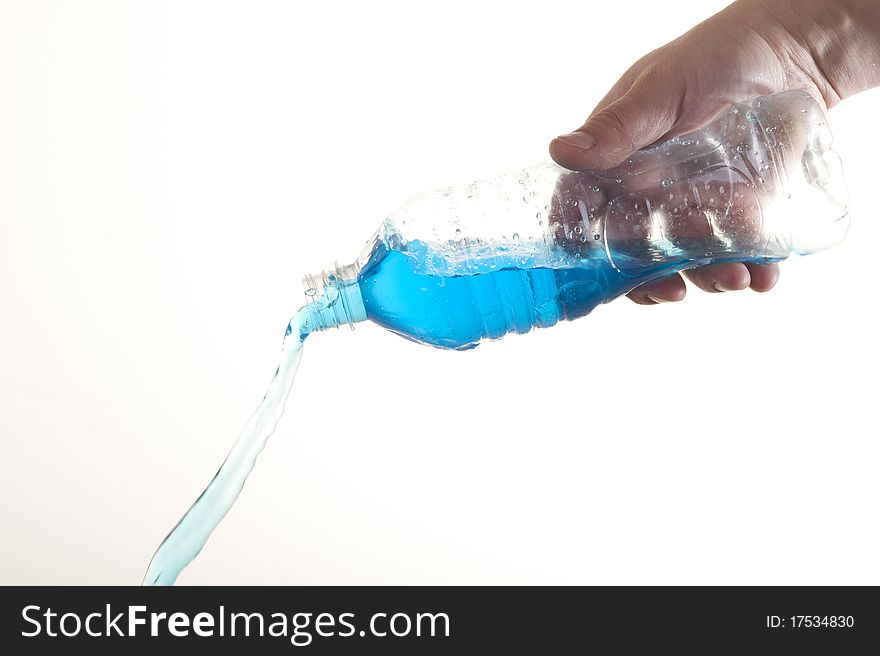 Bottle in a hand. Pouring blue fresh water