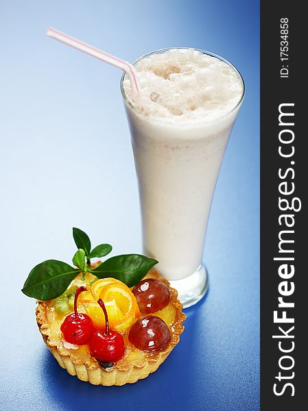 Milkshake and cake on a blue background. Milkshake and cake on a blue background