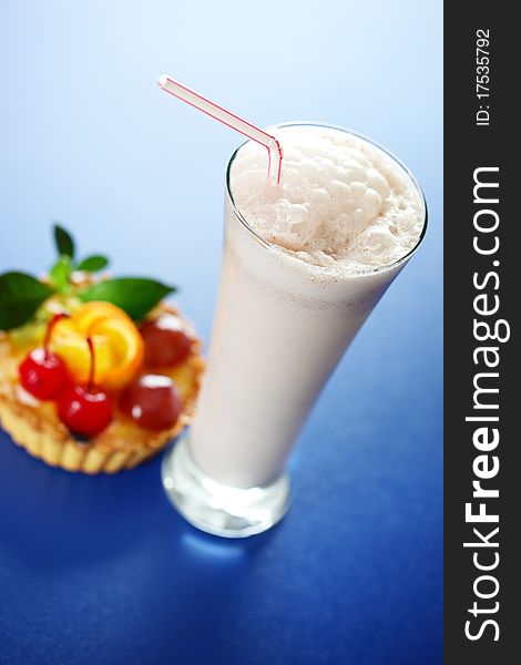 Milkshake and cake on a blue background. Milkshake and cake on a blue background