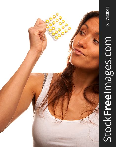 Pretty young woman looking at full medicine pack of yellow tablet pills thinking about doctor's prescription to take one or not isolated on a white background. Pretty young woman looking at full medicine pack of yellow tablet pills thinking about doctor's prescription to take one or not isolated on a white background