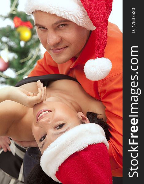 Young lovely couple near a Christmas tree. Isolated over white background