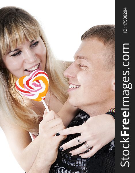 The young couple licking lollypop shape of heart. The young couple licking lollypop shape of heart