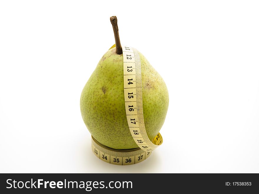 Pear with stem on yellow tape measure. Pear with stem on yellow tape measure