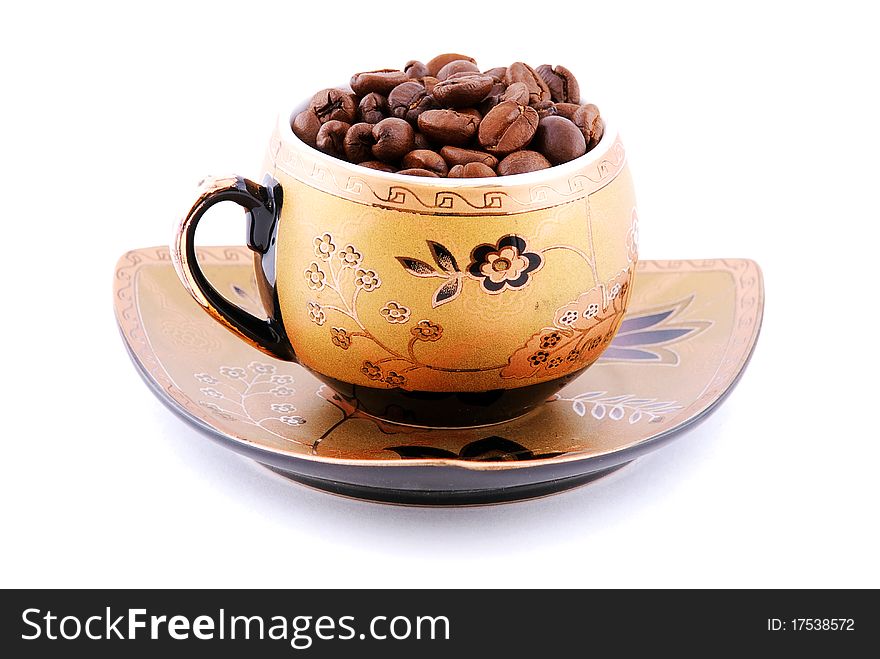 Cup with coffee beans on a plate isolated on white background