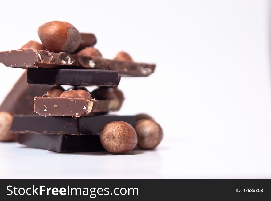 Selection of chocolate squares and nuts isolated on white